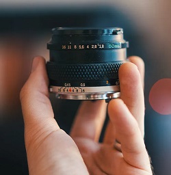 Image of a 50mm prime lens held in someone's hand